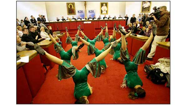 Dancers take obscene poses before a bench of Polish bishops